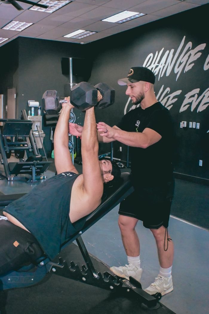 hero-img-02 A personal trainer guides a client during a dumbbell workout in a Scottsdale, Arizona gym.
