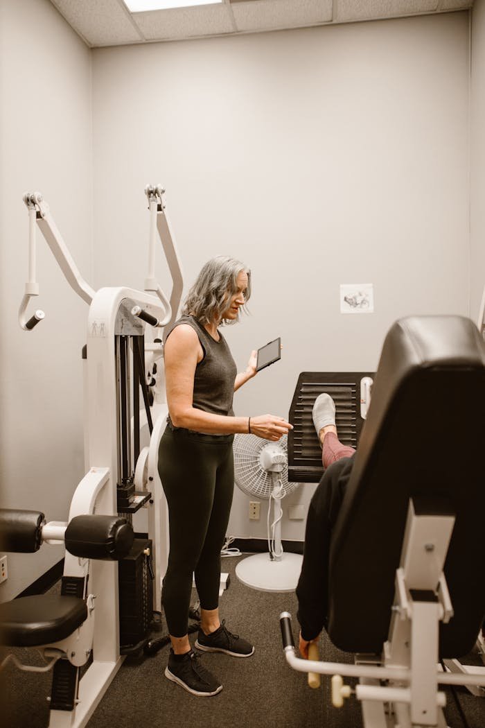 about-01 Woman guiding another in gym for health and wellness support.